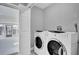 Bright laundry room with full-size white washer and dryer and access to sunroom at 2012 Dorris Dr, Orlando, FL 32807