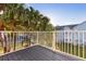 Balcony with metal railing overlooking green space and blue siding of a neighboring building at 2030 Royal Bay Blvd # 62, Kissimmee, FL 34746