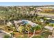 Aerial view of a community pool with lounge chairs, umbrellas, and a clubhouse amidst lush landscaping at 2030 Royal Bay Blvd # 62, Kissimmee, FL 34746