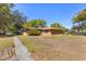 Backyard showing the exterior of the home and large lawn with scattered trees at 209 Camden Rd, Altamonte Springs, FL 32714