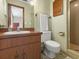 Compact bathroom features wood-look vanity, toilet, and walk-in shower with green tile at 209 Camden Rd, Altamonte Springs, FL 32714