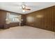 Bedroom features wood-paneled walls, neutral carpet, ceiling fan, and a window at 209 Camden Rd, Altamonte Springs, FL 32714