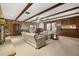 Cozy living room featuring wood paneling, ceiling beams, plush carpeting, and comfortable seating at 209 Camden Rd, Altamonte Springs, FL 32714