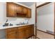 Utility room with wooden cabinets, a stainless steel sink and an open doorway at 209 Camden Rd, Altamonte Springs, FL 32714