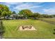 Expansive backyard featuring a fire pit, lush greenery, and a view of the house with a screened patio at 2106 Ridgewind Way, Windermere, FL 34786