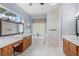 Bright bathroom with double vanities, a soaking tub, glass block window, and a tiled shower at 2106 Ridgewind Way, Windermere, FL 34786