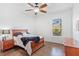 Cozy bedroom with a wooden bed, dark hardwood floors, ceiling fan, and a bright window at 2106 Ridgewind Way, Windermere, FL 34786