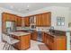 A spacious kitchen featuring granite countertops, stainless steel appliances, and warm wood cabinetry at 2106 Ridgewind Way, Windermere, FL 34786