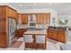 A well-appointed kitchen showcasing an island with seating, stainless steel appliances, and warm wood cabinets at 2106 Ridgewind Way, Windermere, FL 34786