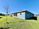 Backyard of home features screened-in porch and lush green grass at 2107 Cartgate Ln, Winter Haven, FL 33884