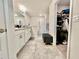 Bathroom featuring white double vanity, tile flooring, a gray accent bench, and a walk-in closet at 2107 Cartgate Ln, Winter Haven, FL 33884