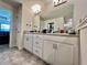 Bathroom vanity featuring white cabinets, granite countertops, double sinks, and tile flooring at 2107 Cartgate Ln, Winter Haven, FL 33884