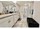 Bright bathroom featuring white double vanity, granite counters, and tile flooring at 2107 Cartgate Ln, Winter Haven, FL 33884