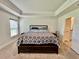 Bright main bedroom featuring neutral walls, carpet, tray ceiling, and access to the ensuite bathroom at 2107 Cartgate Ln, Winter Haven, FL 33884