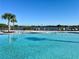 Community pool featuring lounge chairs and a view of the nearby lake at 2107 Cartgate Ln, Winter Haven, FL 33884