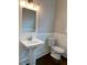 Powder room featuring a pedestal sink, wood floors, and traditional wainscoting at 2108 Delaney Ave, Orlando, FL 32806