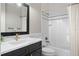 Stylish bathroom featuring a black vanity with marble countertop next to a bathtub and shower combination at 2108 Delaney Ave, Orlando, FL 32806