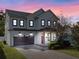 Charming two-story home features a brick driveway, attached garage, and a picturesque sunset backdrop at 2108 Delaney Ave, Orlando, FL 32806