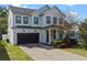 Inviting two-story home with a dark garage door, red front door, and landscaped front yard at 2108 Delaney Ave, Orlando, FL 32806