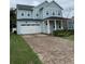 Charming two-story home featuring a brick driveway, well-manicured lawn, and cozy porch at 2108 Delaney Ave, Orlando, FL 32806