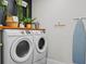 Well-organized laundry room featuring front loading washer and dryer with decorative plants on top at 2108 Delaney Ave, Orlando, FL 32806