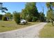 Long gravel driveway leading to a well-maintained property with mature trees and lush greenery at 2525 S Sanford Avenue Ave, Sanford, FL 32773