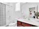 Bright bathroom featuring a dark-wood vanity, large mirror, and a shower/tub combo with striped curtain at 2557 Shanti Dr, Kissimmee, FL 34746