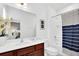 Bright bathroom featuring a dark-wood vanity, large mirror, and a shower/tub combo with blue-striped curtain at 2557 Shanti Dr, Kissimmee, FL 34746