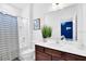 Bright bathroom featuring a dark-wood vanity, large mirror, and a shower/tub combo with white-striped curtain at 2557 Shanti Dr, Kissimmee, FL 34746