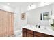 Bright bathroom featuring a dark-wood double vanity, large mirror, and a shower/tub combo at 2557 Shanti Dr, Kissimmee, FL 34746