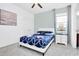 Bright bedroom featuring a white-framed bed with blue patterned bedding and a modern nightstand at 2557 Shanti Dr, Kissimmee, FL 34746