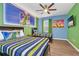 Vibrant bedroom with fun themed decor, wooden floor, two beds, and a ceiling fan at 2557 Shanti Dr, Kissimmee, FL 34746