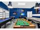 A game room features a pool table, foosball table, and entertainment center with blue painted walls at 2557 Shanti Dr, Kissimmee, FL 34746