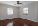 Bright bedroom with wood laminate flooring, two windows, and a modern ceiling fan at 2661 Jennifer Hope Blvd, Longwood, FL 32779