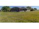 View of backyard screened-in pool and a large grassy area extending toward neighborhood homes at 2904 Sweetspire Cir, Kissimmee, FL 34746