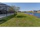 Expansive backyard featuring a screened-in pool, lush green grass, and water view at 2904 Sweetspire Cir, Kissimmee, FL 34746