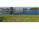 Lush backyard and a scenic view of a pond and neighboring houses on a sunny day at 2904 Sweetspire Cir, Kissimmee, FL 34746