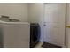 Laundry room with modern washer and dryer units next to an exterior door at 2904 Sweetspire Cir, Kissimmee, FL 34746