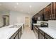 Modern kitchen featuring stainless steel appliances, dark cabinets, and marble countertops at 325 St Georges Cir, Eagle Lake, FL 33839