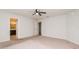 Bright main bedroom featuring neutral carpet, ceiling fan, and ensuite bathroom at 325 St Georges Cir, Eagle Lake, FL 33839