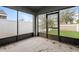 Enclosed patio with concrete flooring, screen door, and views of backyard and trees at 325 St Georges Cir, Eagle Lake, FL 33839