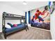 Themed ' bedroom featuring bunk beds, carpet flooring, and colorful murals of superheroes at 4405 Durga Ln, Kissimmee, FL 34746