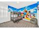 Themed ' bedroom featuring bunk beds, a beanbag chair, carpet flooring, and a colorful cartoon mural at 4405 Durga Ln, Kissimmee, FL 34746