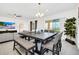 Bright dining area featuring a large dark wood table, ample seating, and sliding glass doors leading to outdoor space at 4405 Durga Ln, Kissimmee, FL 34746