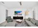 Modern living room featuring a gray sectional, patterned armchair, and sleek entertainment center beneath a large flat-screen TV at 4405 Durga Ln, Kissimmee, FL 34746