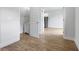 Hallway with wood flooring leading to a bathroom on the left and kitchen on the right at 4409 Summer Flowers Pl, Kissimmee, FL 34746