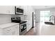 A modern kitchen featuring stainless steel appliances, white cabinets, and wood-look floors at 4409 Summer Flowers Pl, Kissimmee, FL 34746