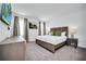 Spacious bedroom featuring neutral paint, carpet and trim, a dresser and bedside table with lamps at 4421 Durga Ln, Kissimmee, FL 34746