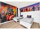 ' bedroom boasts light wood floors, superhero themed wall decor and bright white trim at 4421 Durga Ln, Kissimmee, FL 34746