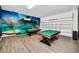 Spacious game room featuring two pool tables and vibrant wall art for entertainment at 4421 Durga Ln, Kissimmee, FL 34746